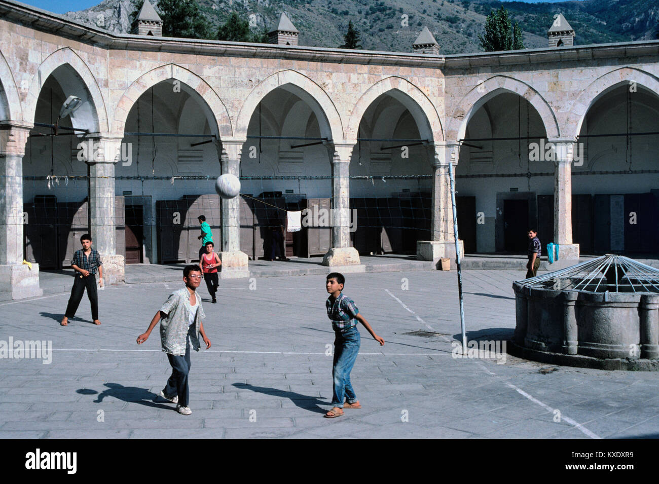 Les garçons turcs jouer Volley-ball ou au football dans la Cour octogonale du c 15ème Aga Medrese Buyuk ou Kapi Aga Medresesi, Amasya, Turquie Banque D'Images