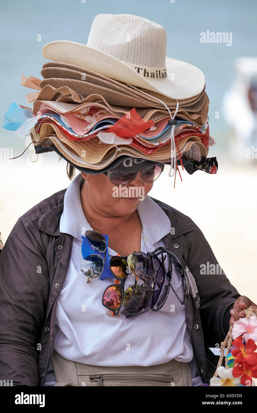 Vendeur de rue en Thaïlande. Les femmes la vente d'une sélection de chapeaux et porter tout. Scène de rue, amusantes Banque D'Images