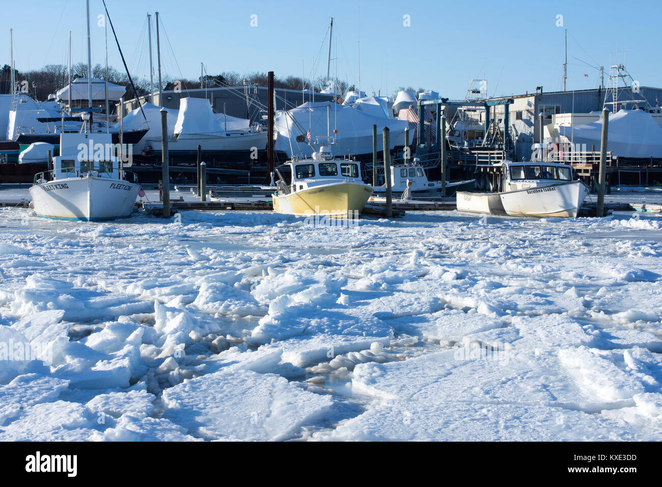 Amarré et stockés bateaux à la frozen Sesuit Harbor, Dennis, Cape Cod, Massachusetts, USA par une froide journée d'hiver Banque D'Images