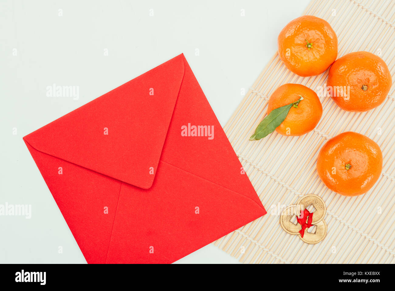 Vue de dessus de l'enveloppe rouge avec les tangerines et pièces de monnaie chinoise talisman, concept du Nouvel An chinois Banque D'Images