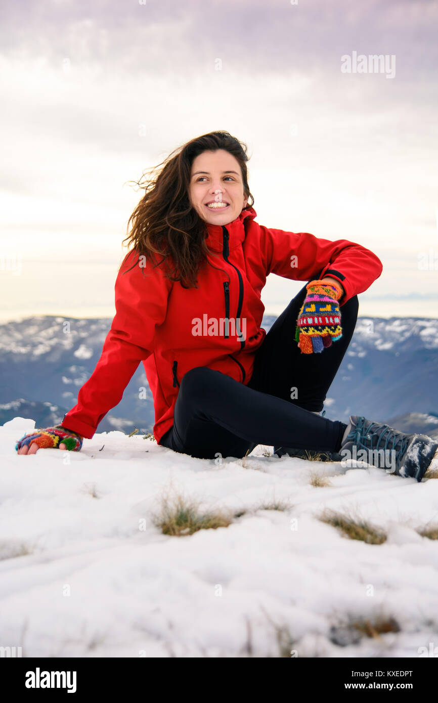 Female hiker assis sur la montagne couverte de neige dessus. Mode de vie actif d'hiver Banque D'Images