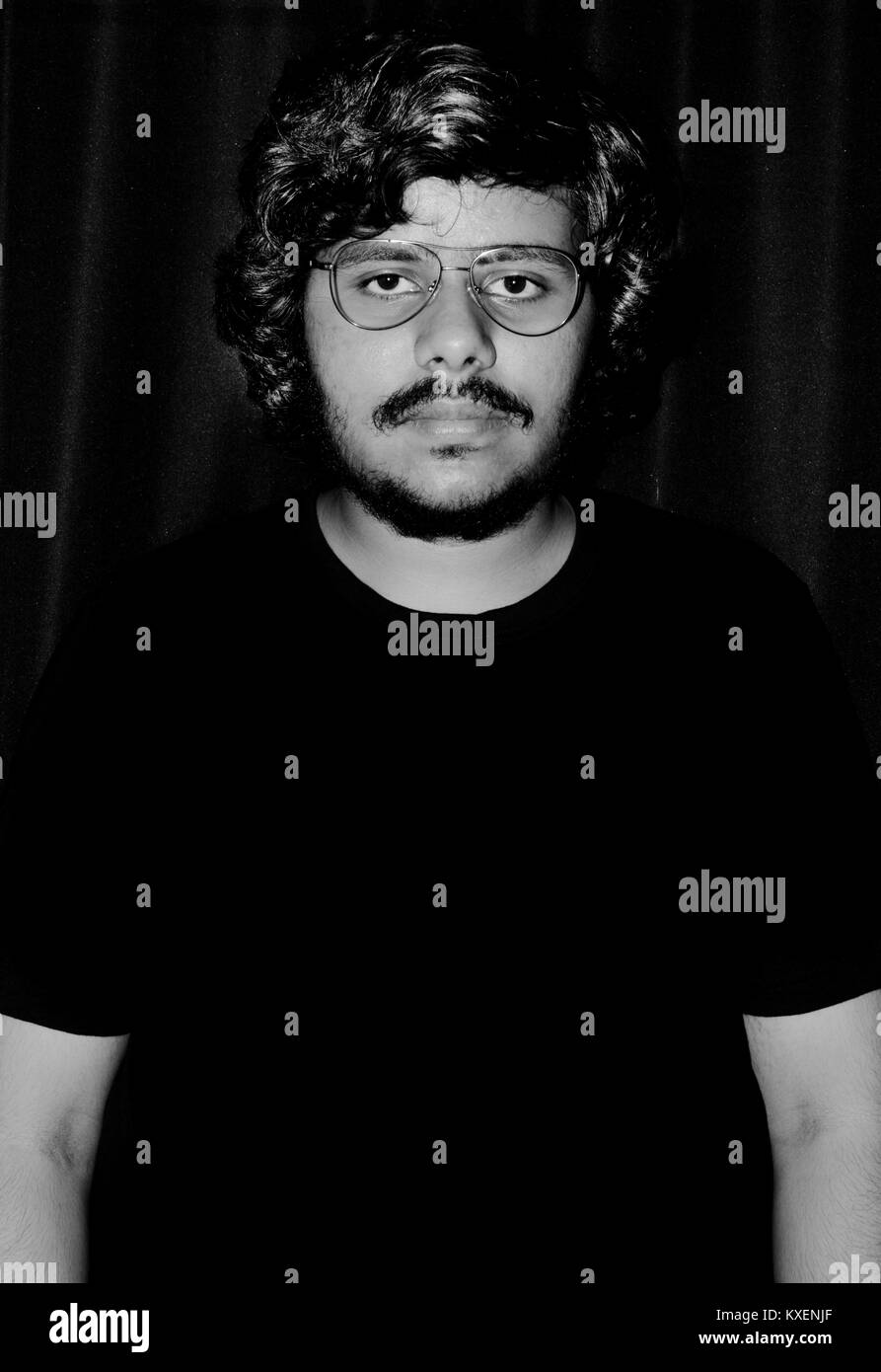 Portrait de jeune homme à lunettes sur fond noir. Banque D'Images