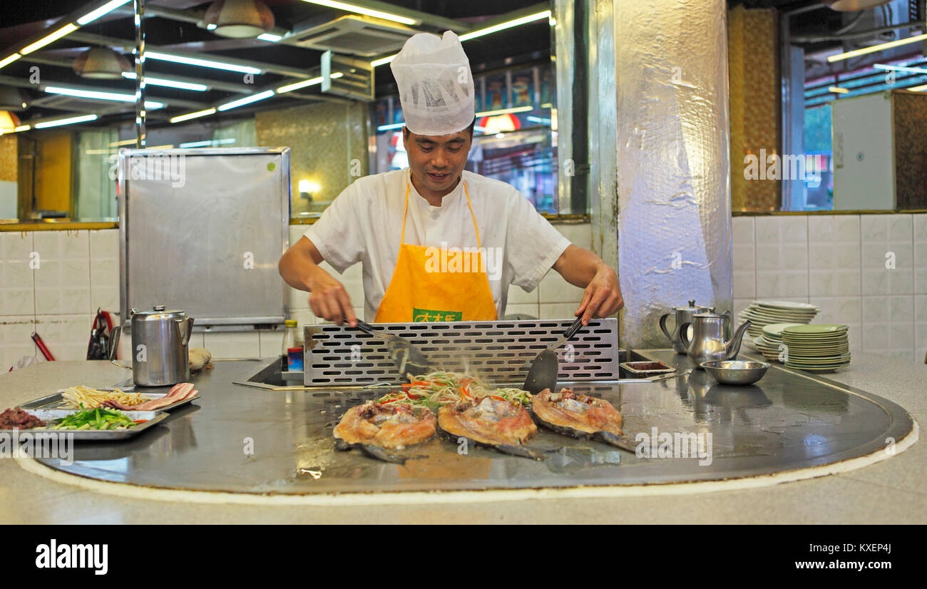 Faire cuire dans une cuisine de cuisson, la préparation des poissons, Chengdu, Sichuan, Chine Banque D'Images