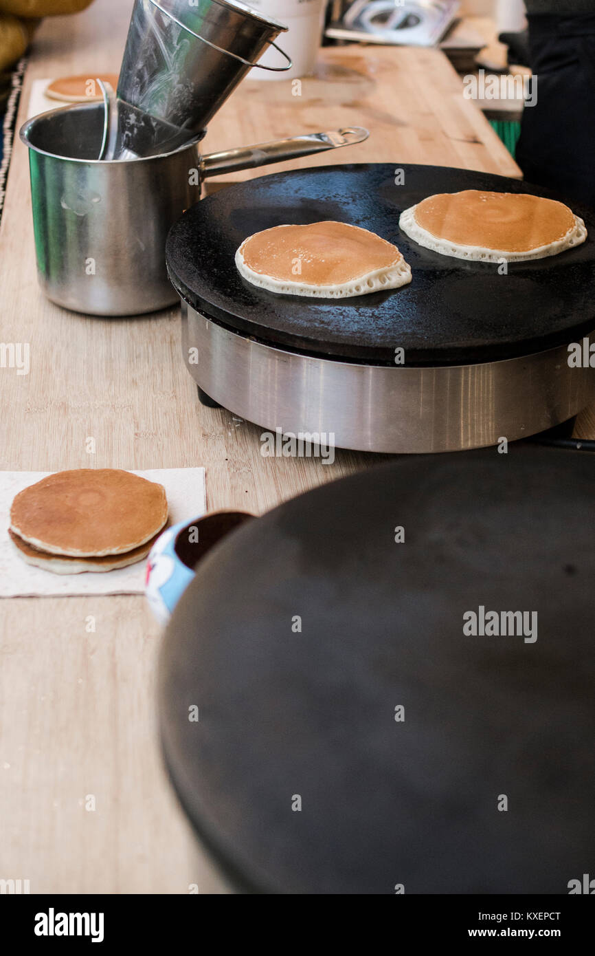 Dorayakis ou crêpes japonais étant faite sur une plaque noire à un camion alimentaire Banque D'Images