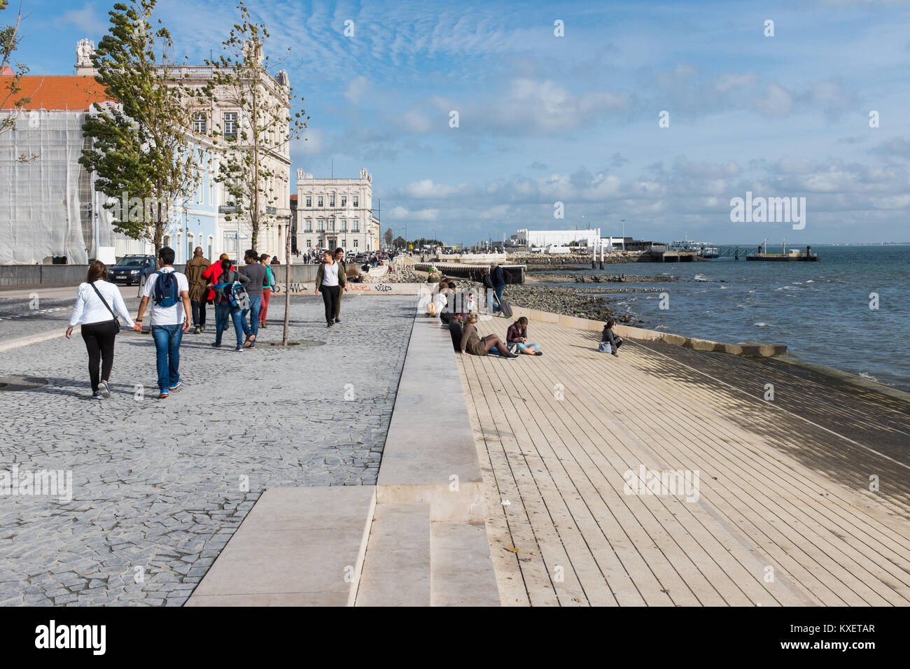 Les gens qui marchent le long de la promenade du bord de mer sur Ribeira das Naus à Lisbonne, Portugal à la fin de l'automne Sunshine Banque D'Images