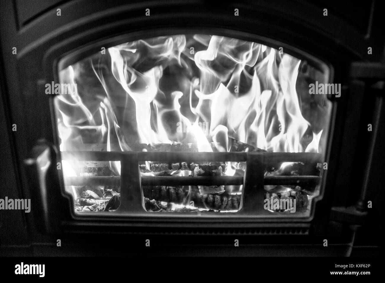 Bois de chauffage en feu vu à travers la fenêtre d'une cuisinière, détails intérieurs campagne Banque D'Images
