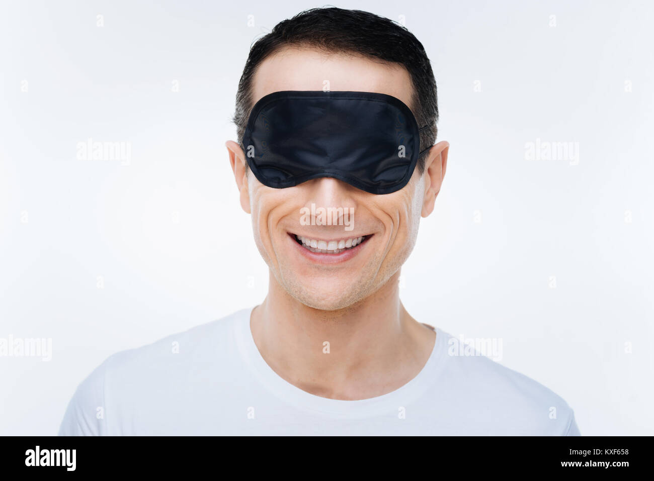Heureux l'homme positif portant un masque de sommeil Banque D'Images