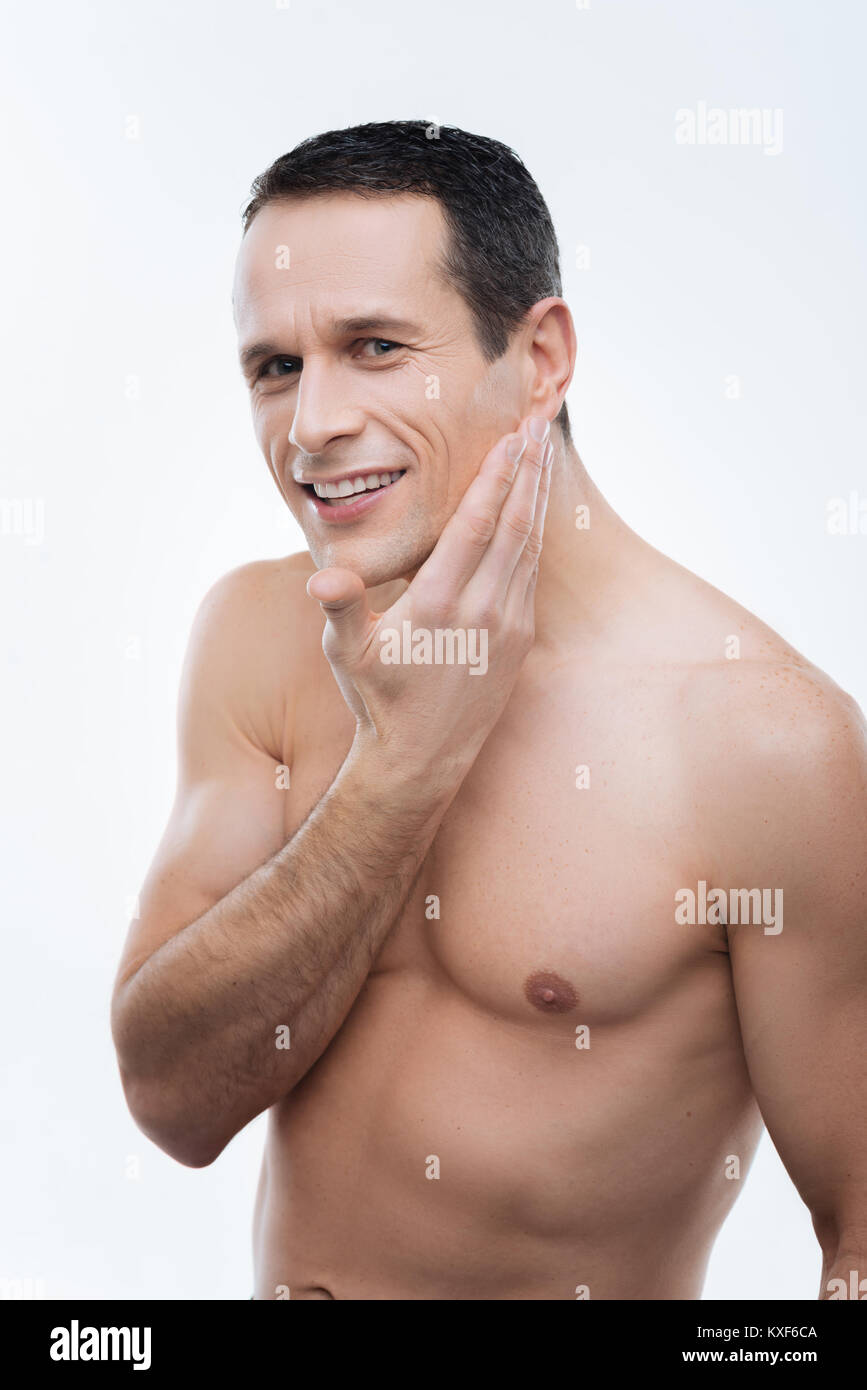 Heureux homme agréable de toucher son visage Banque D'Images