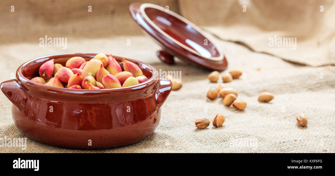 Les pistaches en coque frais dans un pot en céramique Banque D'Images