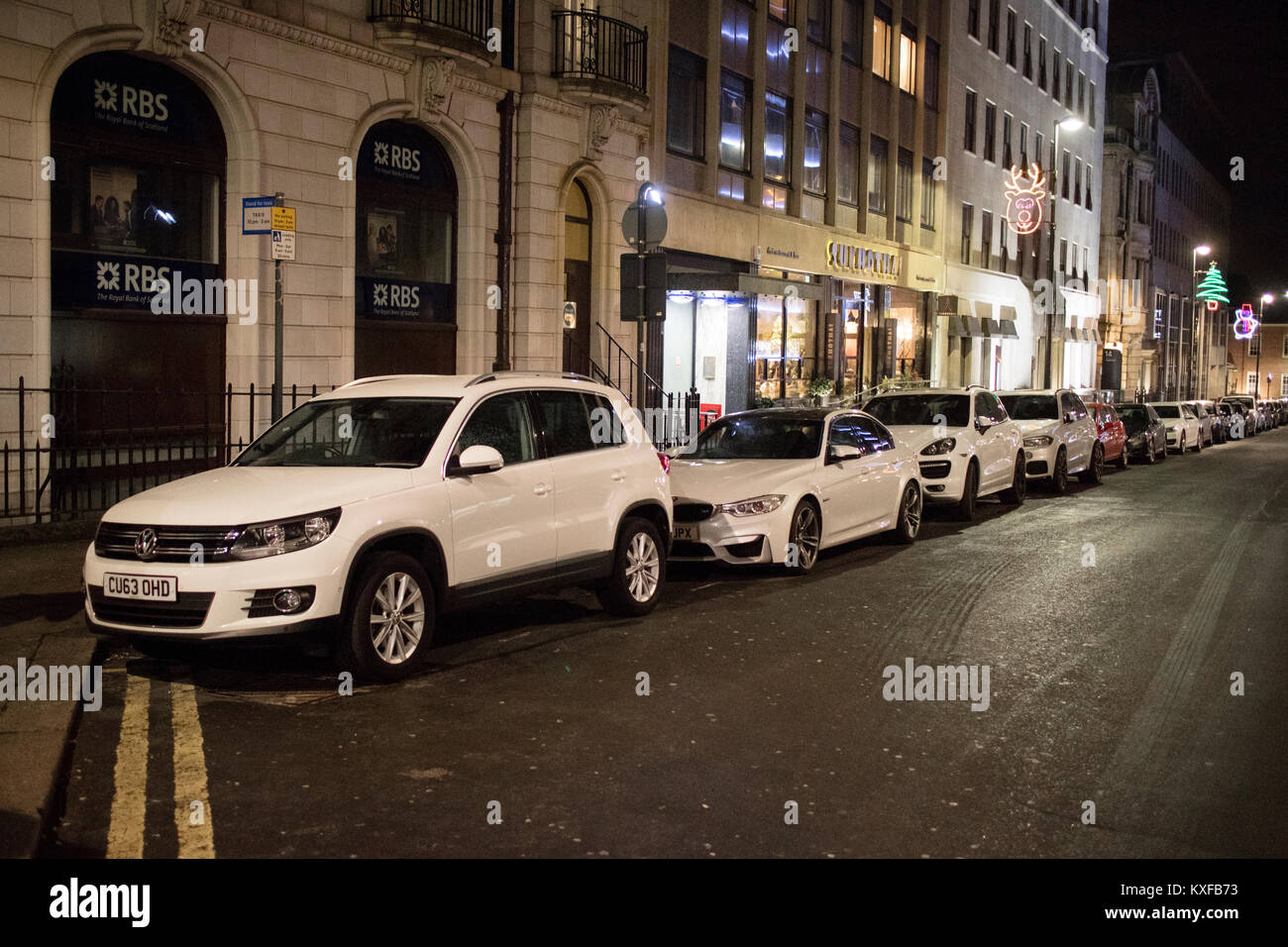 Rangée de voitures garées allemand blanc principalement dans le centre-ville de Leeds de nuit Banque D'Images