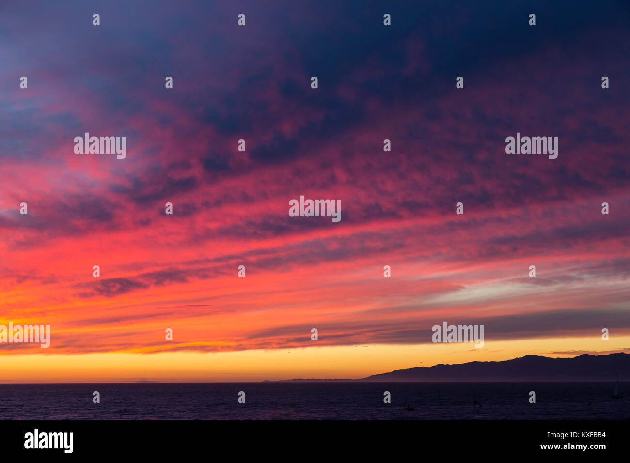 Sunset point rouge s'allume en nuages sur la baie de Santa Monica et bord de la montagnes de Santa Monica comme vu de la plage Playa Del Rey. Point Dume est visible je Banque D'Images