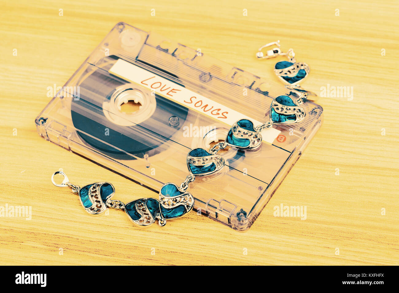 Cassette audio avec l'étiquette des chansons d'amour sur fond de bois. Carte postale de la Saint-Valentin, le ton des couleurs rétro Banque D'Images