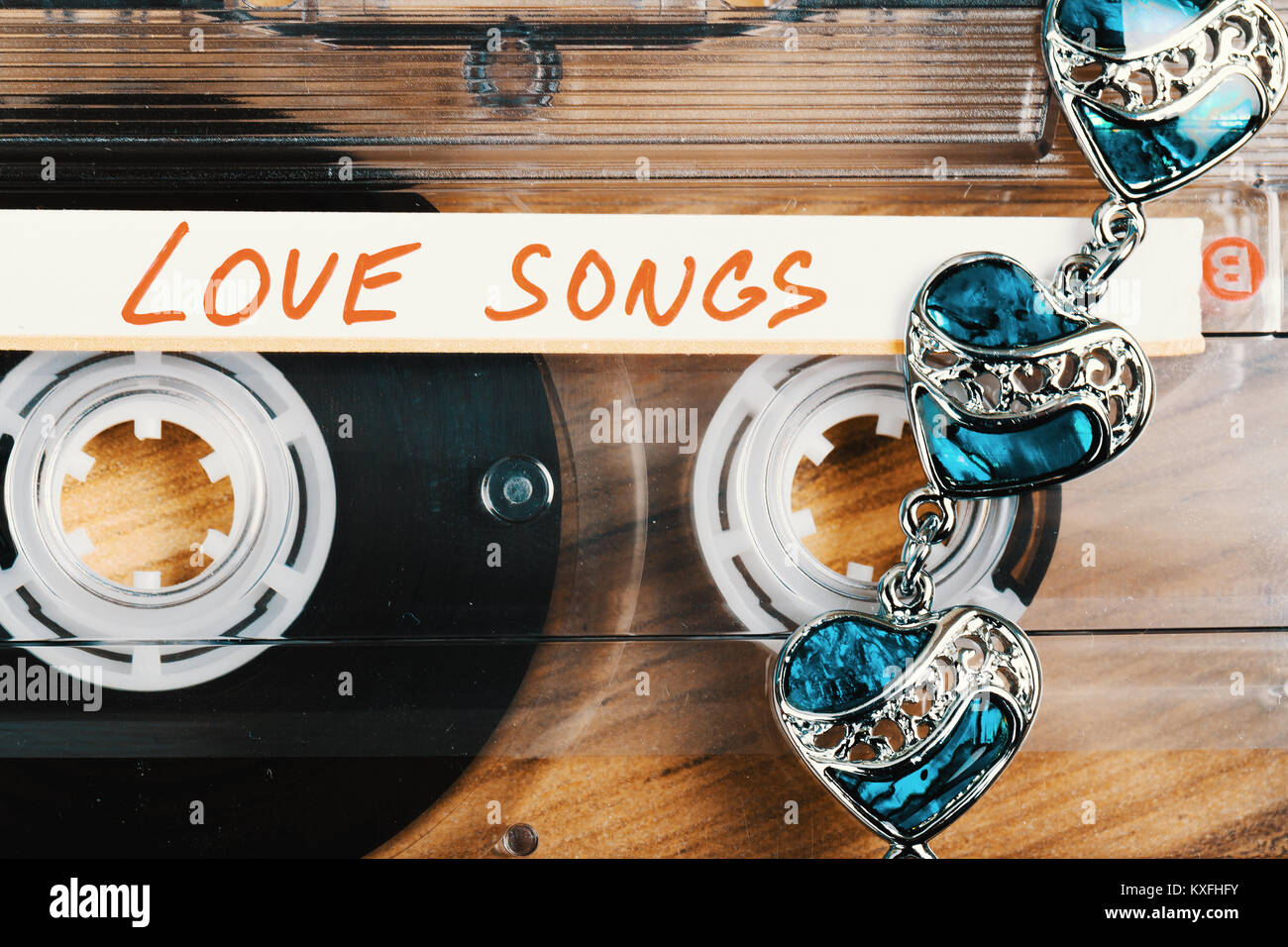 Cassette audio avec l'étiquette des chansons d'amour sur fond de bois. Carte postale de la Saint-Valentin, le ton des couleurs rétro Banque D'Images