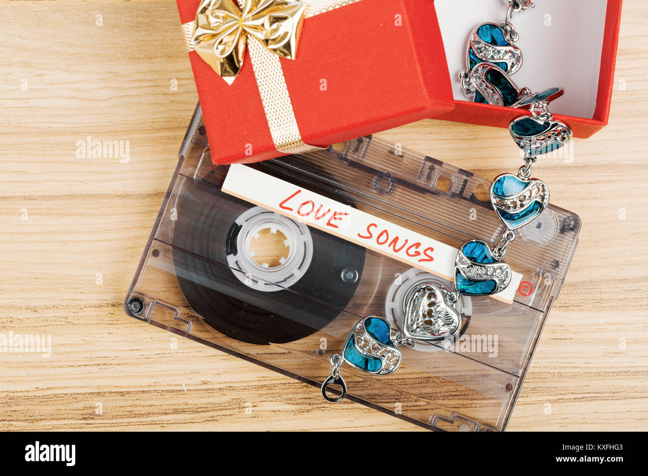 Cassette audio avec l'étiquette des chansons d'amour sur fond de bois. Carte postale de la Saint-Valentin, le ton des couleurs rétro Banque D'Images