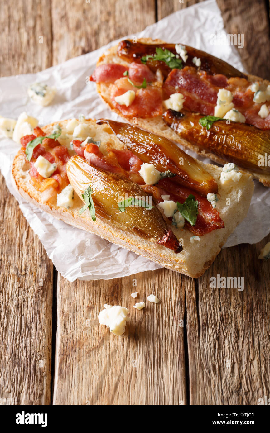 De délicieux sandwiches avec échalotes balsamique caramélisé, bacon et fromage de Roquefort close-up sur la table verticale. Banque D'Images