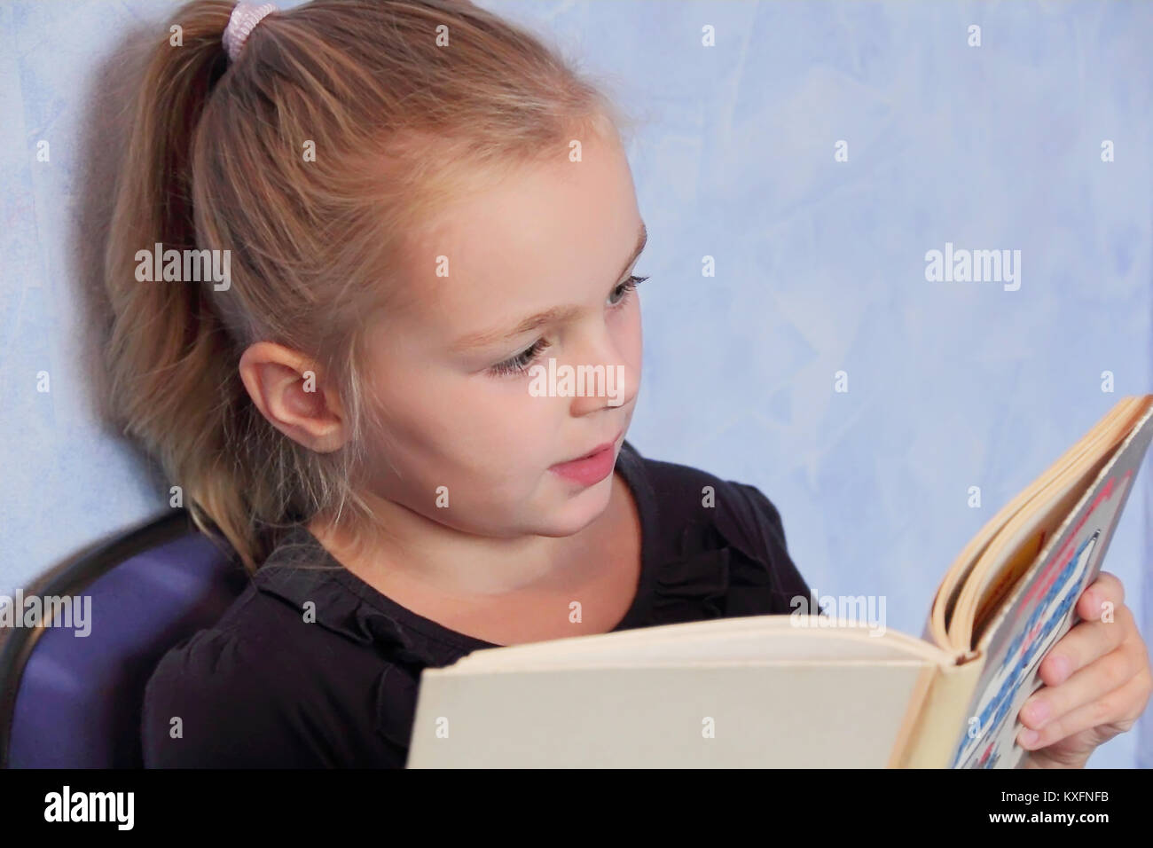 Portrait de jeune fille aux cheveux blonds en lisant un livre Banque D'Images