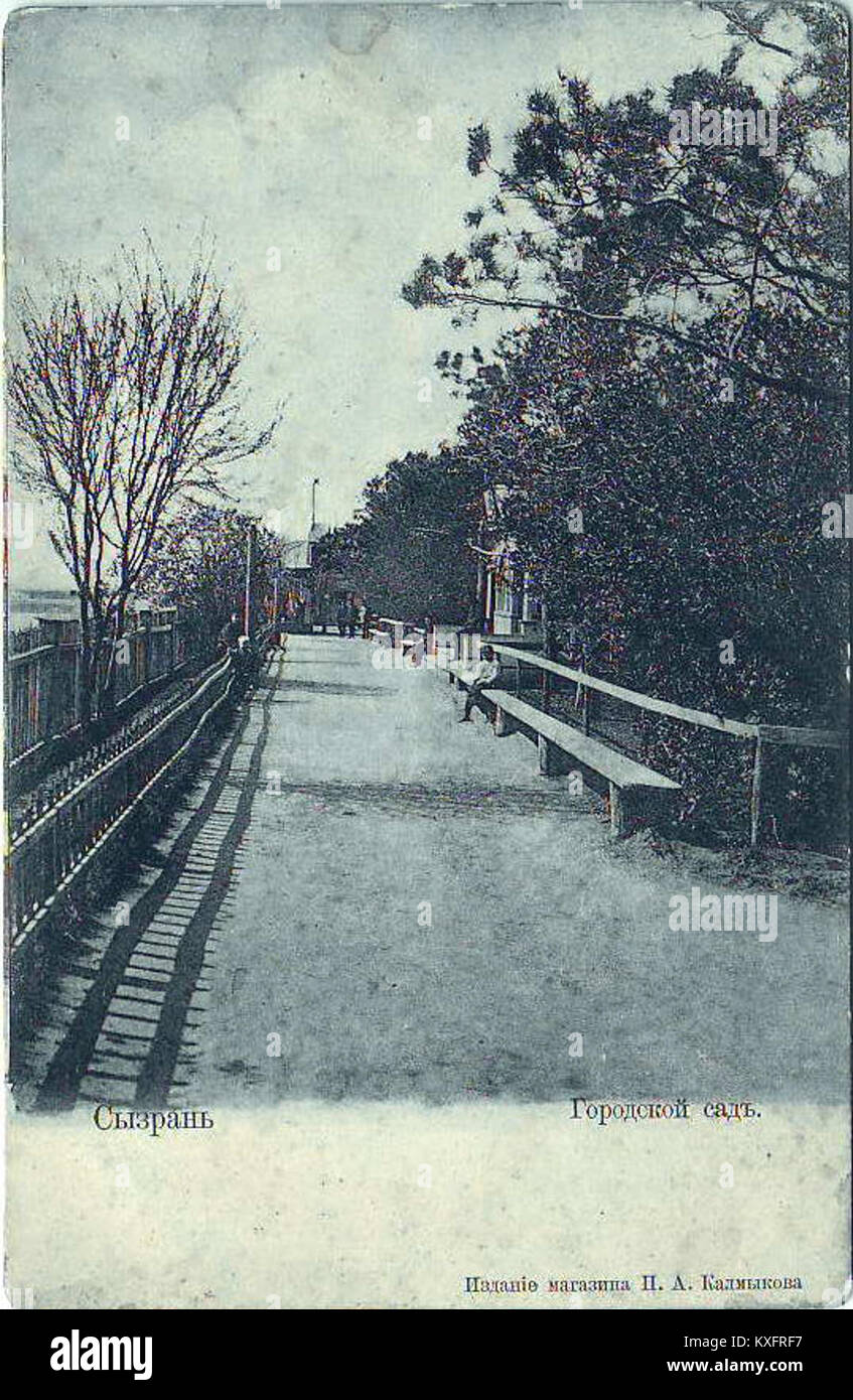 Vue du jardin de la ville (Городской сад) à Syzran, Russie, montrant des promenades bordées d'arbres, des bancs, des parterres de fleurs et une structure centrale de kiosque à musique dans un parc urbain du XIXe siècle. Banque D'Images