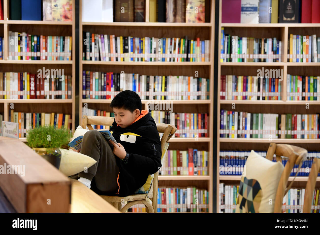 Hefei, Chine, Anhui Province. Jan 9, 2018. Un garçon lit un livre à un centre de lecture à Hefei, capitale de la Chine de l'est la province de l'Anhui, le 9 janvier 2018. Environ 100 centres de lecture sera établi à Hefei dans les deux prochaines années, agissant comme les deux bibliothèques et librairies pour les gens. Credit : Liu Junxi/Xinhua/Alamy Live News Banque D'Images