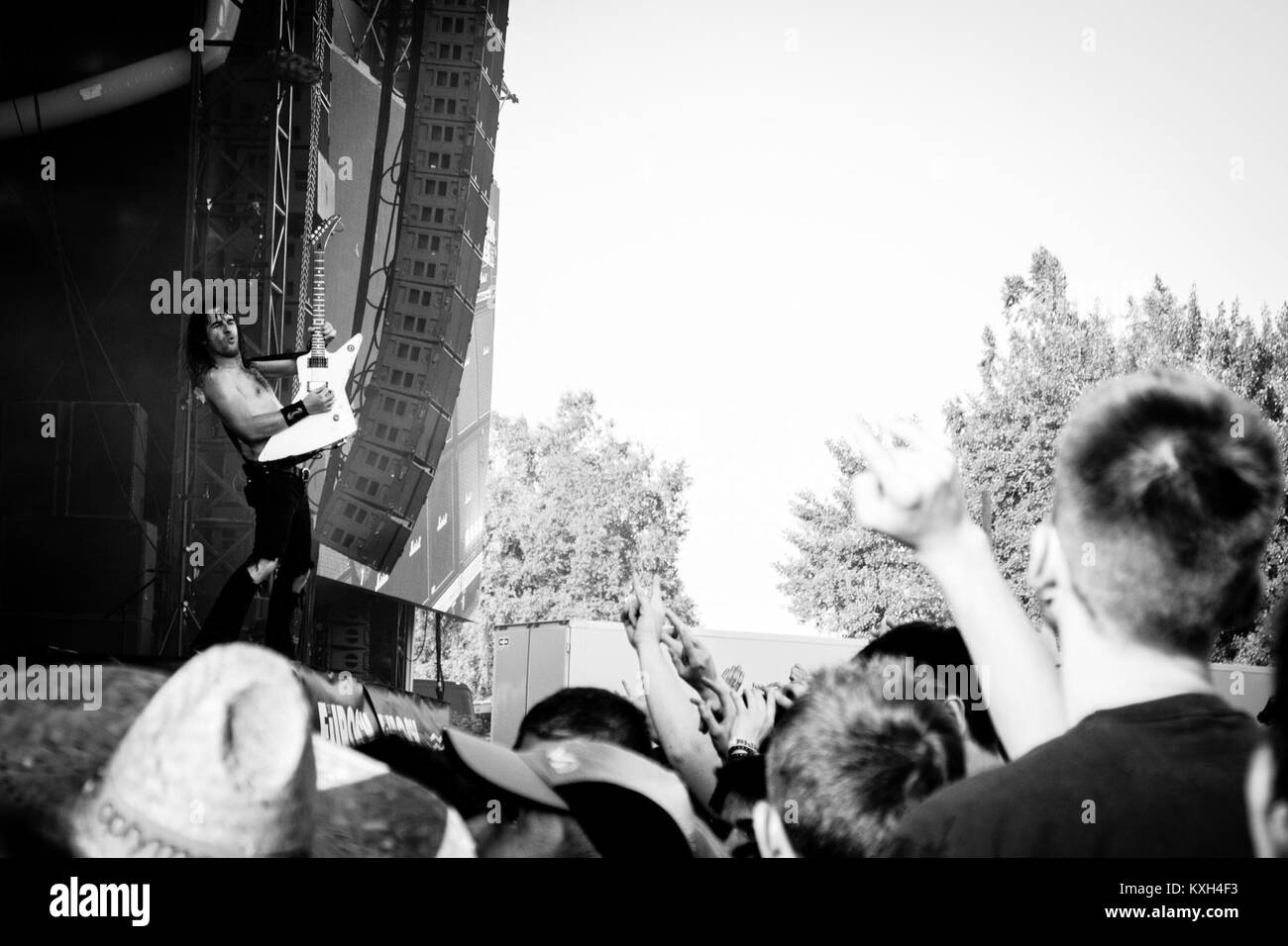 Une photographie du groupe de rock australien Airbourne jouant en concert au Festival Eurockéennes de Belfort en 2013, mettant en valeur la performance musicale et l'interaction avec le public. Banque D'Images