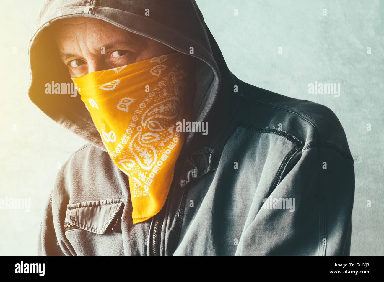 Membre de gang à capuchon avec écharpe sur le visage criminel looking at camera, portrait portrait Banque D'Images