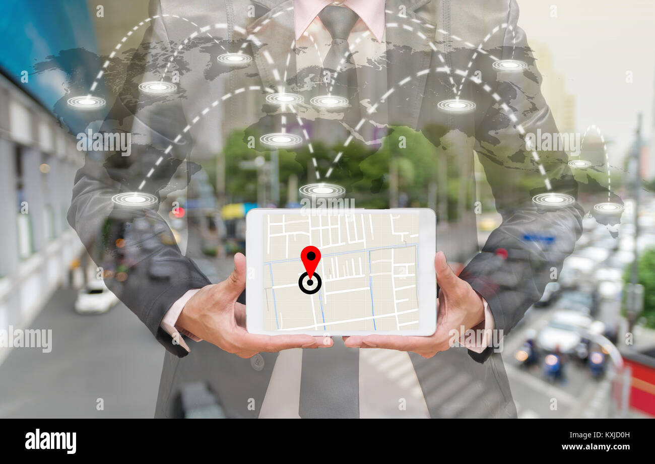 Businessman holding a tablet montrant une partie de la carte de navigation sur la ligne de connexion sur la carte du monde avec des photos floues de l'embouteillage, concept de navigation Banque D'Images