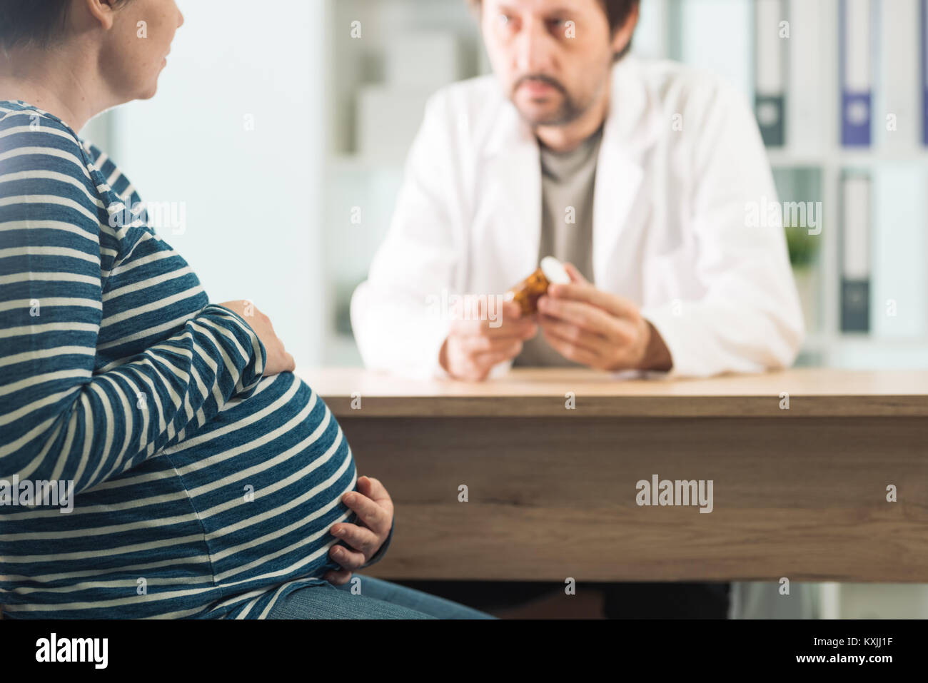 Médecin prescrivant comprimés pour femme enceinte. Soins de santé et aux médicaments pendant la grossesse. Banque D'Images