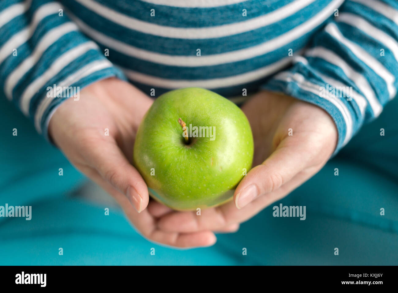 Pregnant woman holding green apple en tant que symbole de la santé Banque D'Images