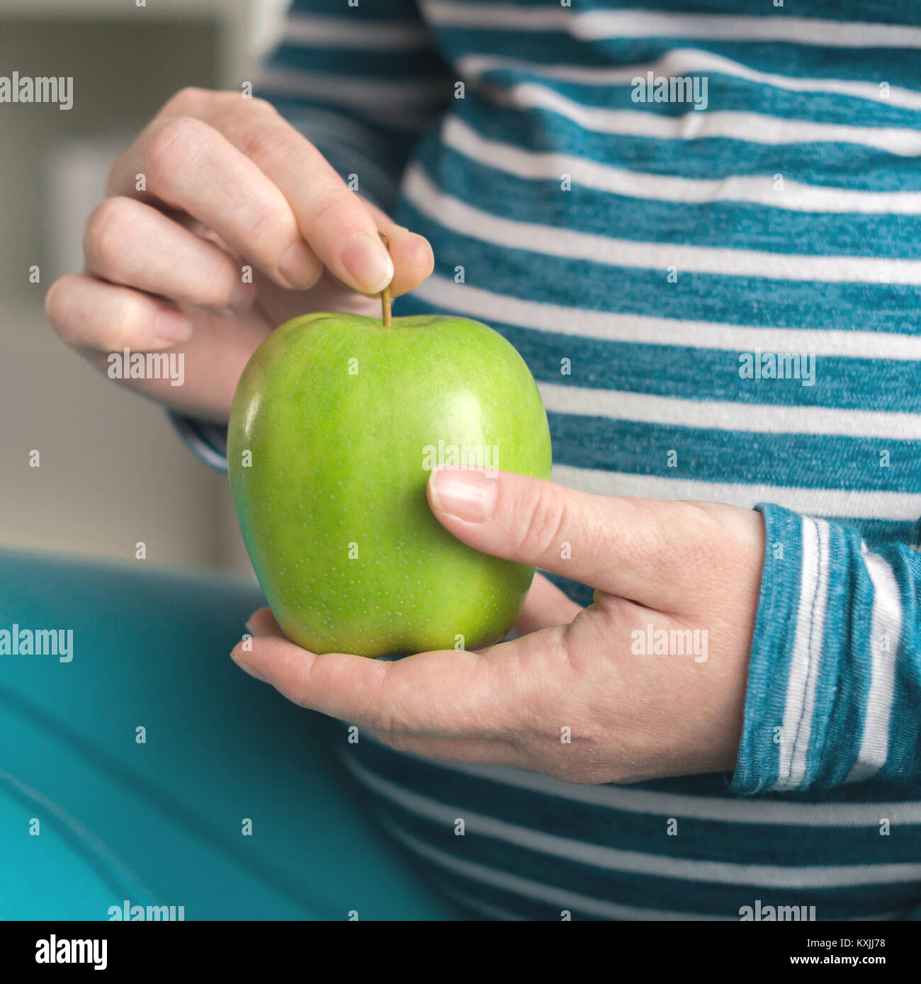 Pregnant woman holding green apple en tant que symbole de la santé Banque D'Images