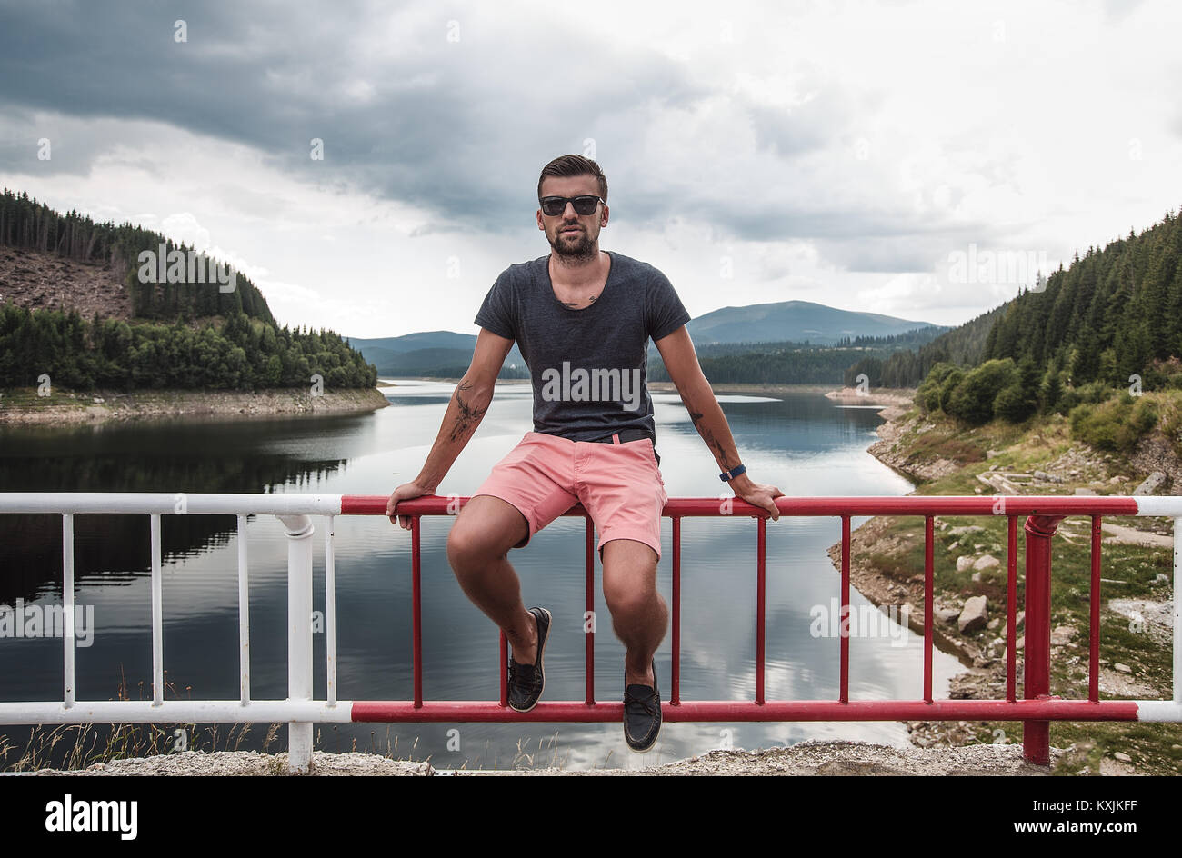 Homme assis sur barrière de sécurité par le lac, Koralat, Zagrebacka, Croatie Banque D'Images