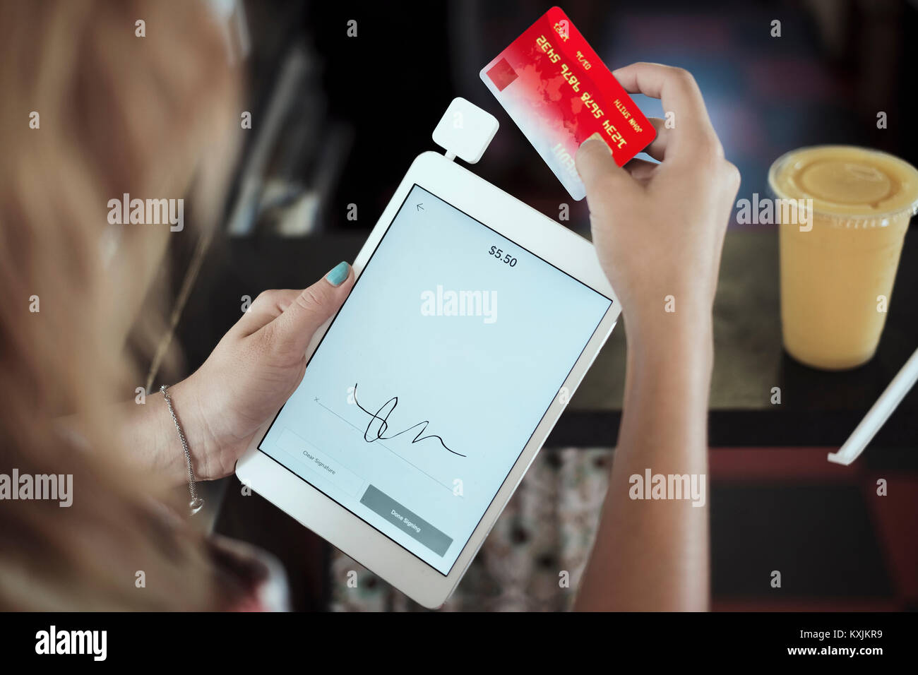 Plus d'épaule de young woman holding digital tablet, une carte de crédit Banque D'Images