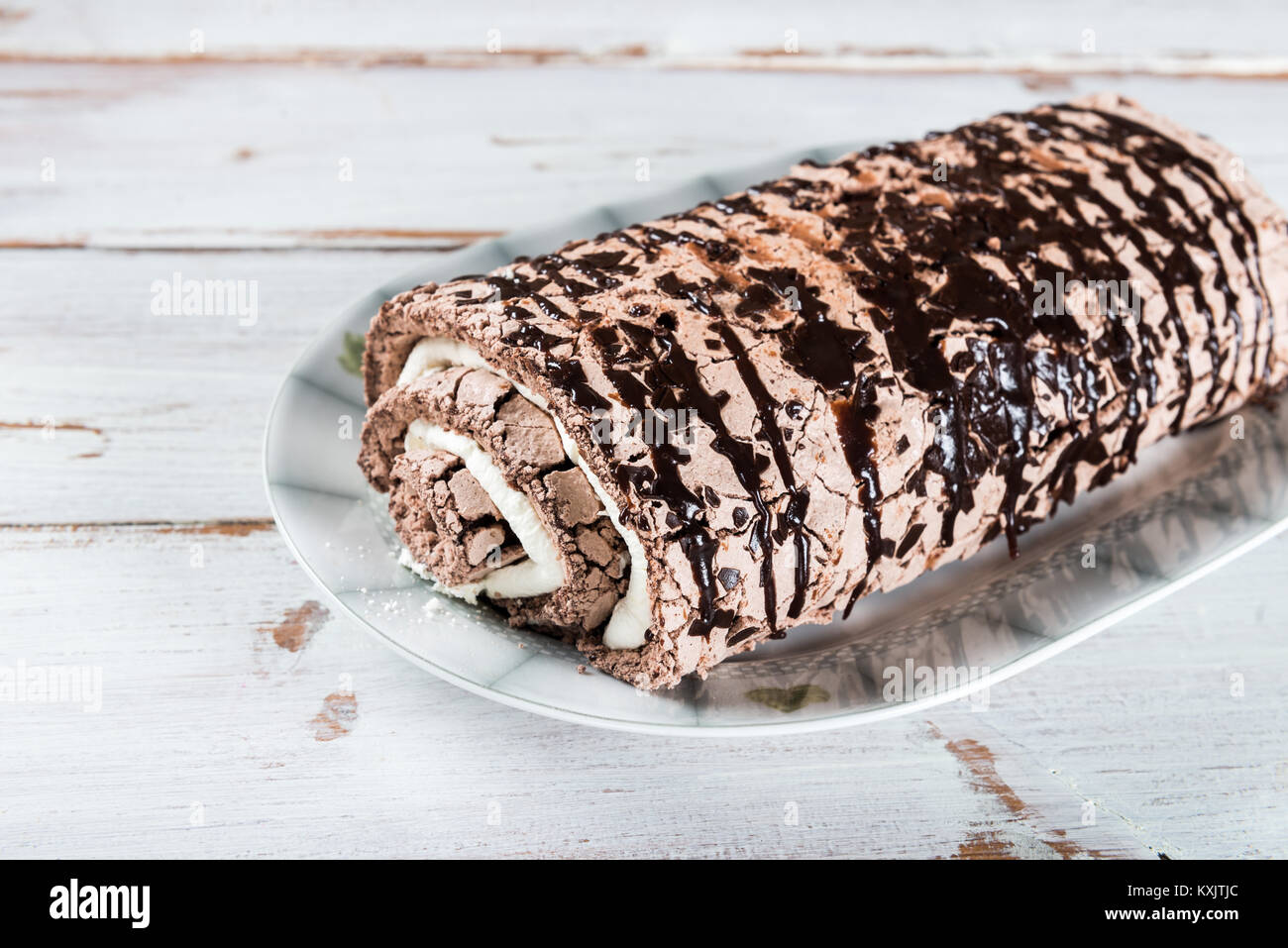 Roulade de meringue chocolat belge rempli de crème chantilly et sauce au chocolat Banque D'Images