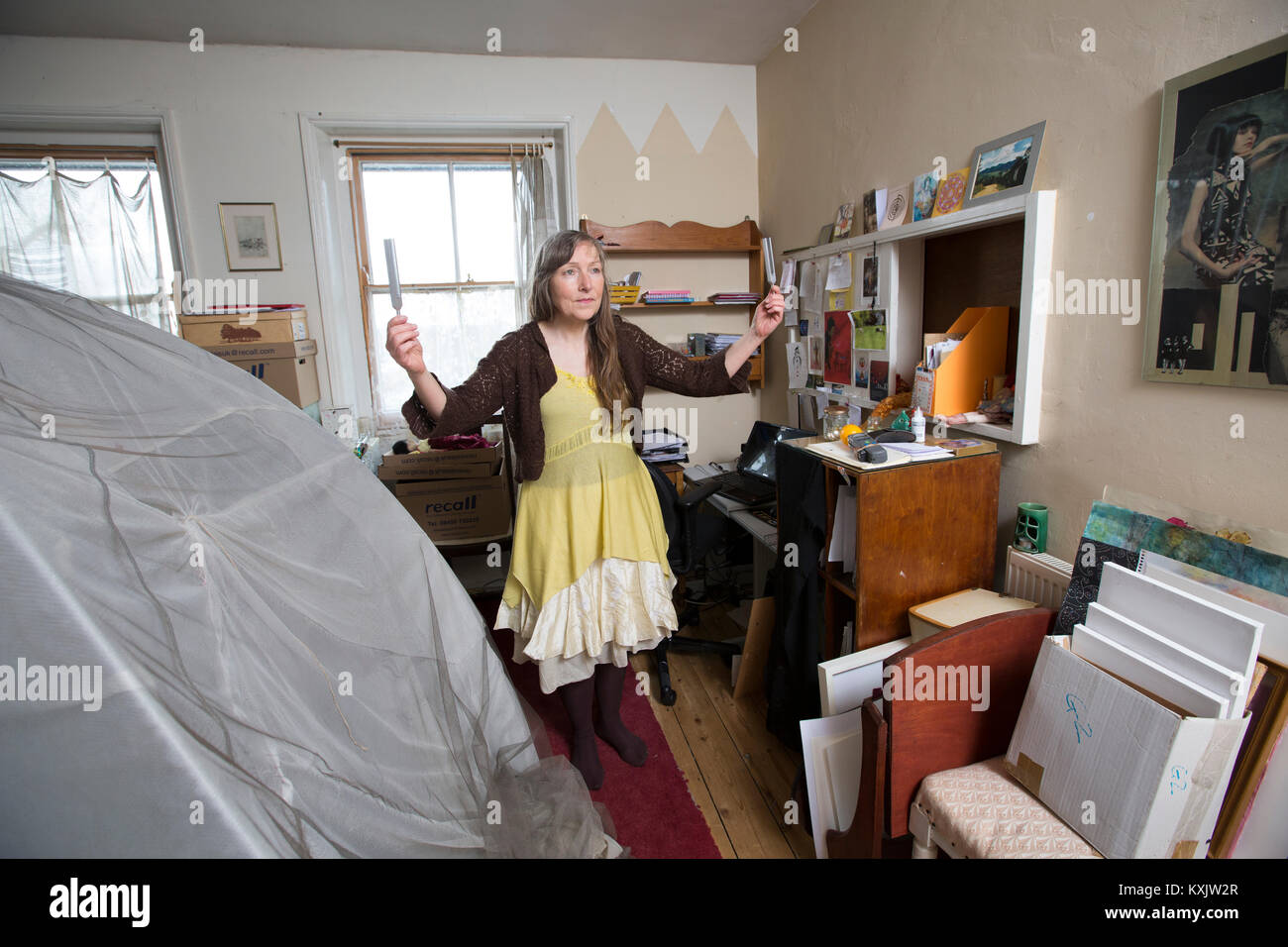 Femme qui souffre du syndrome d'hypersensibilité électromagnétique de l'intolérance qui y est associée (EHS) maintenant la guérison Diapasons et dort à l'intérieur d'une cage de Faraday, UK Banque D'Images