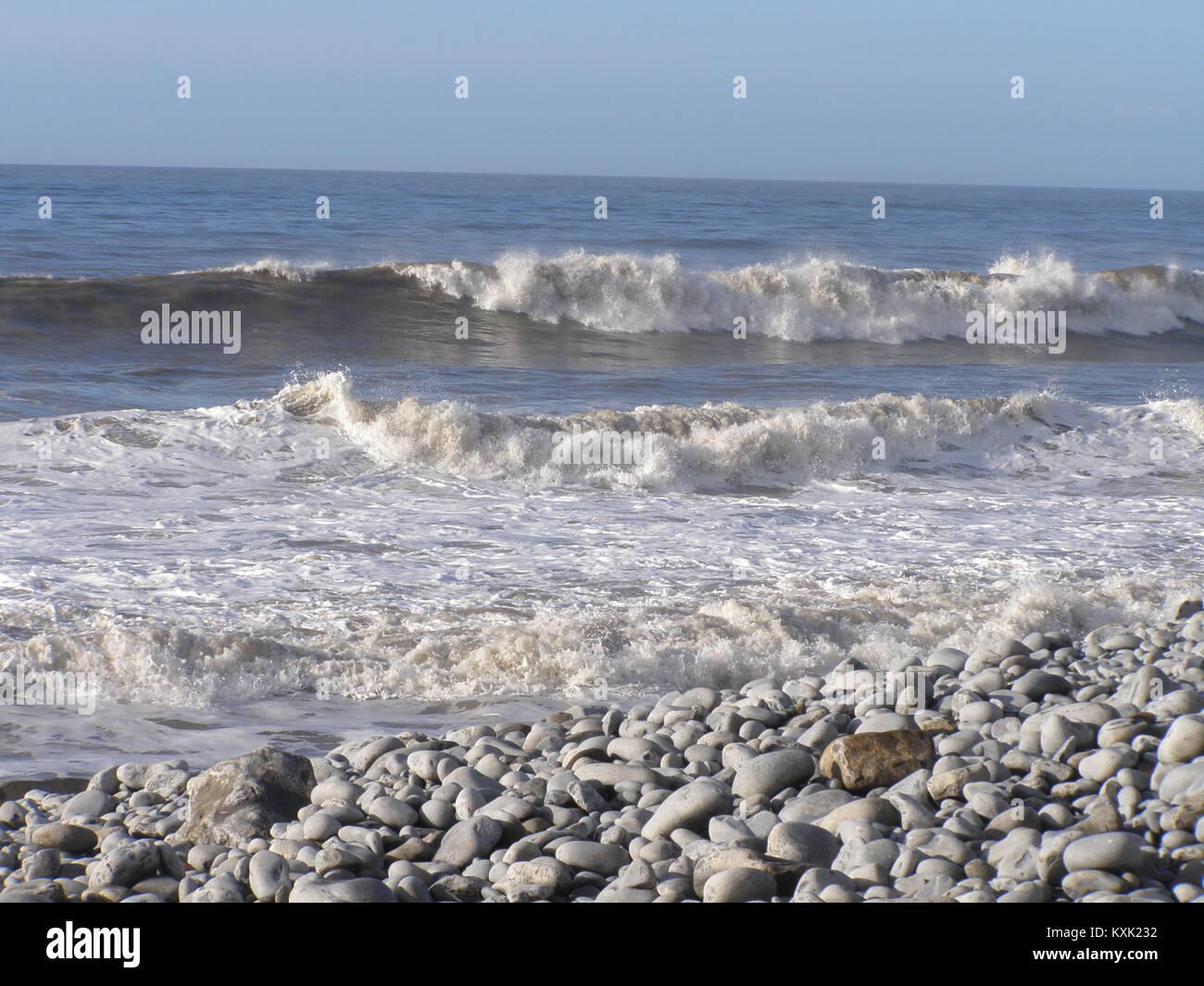 Briser les vagues sur une plage de galets Banque D'Images