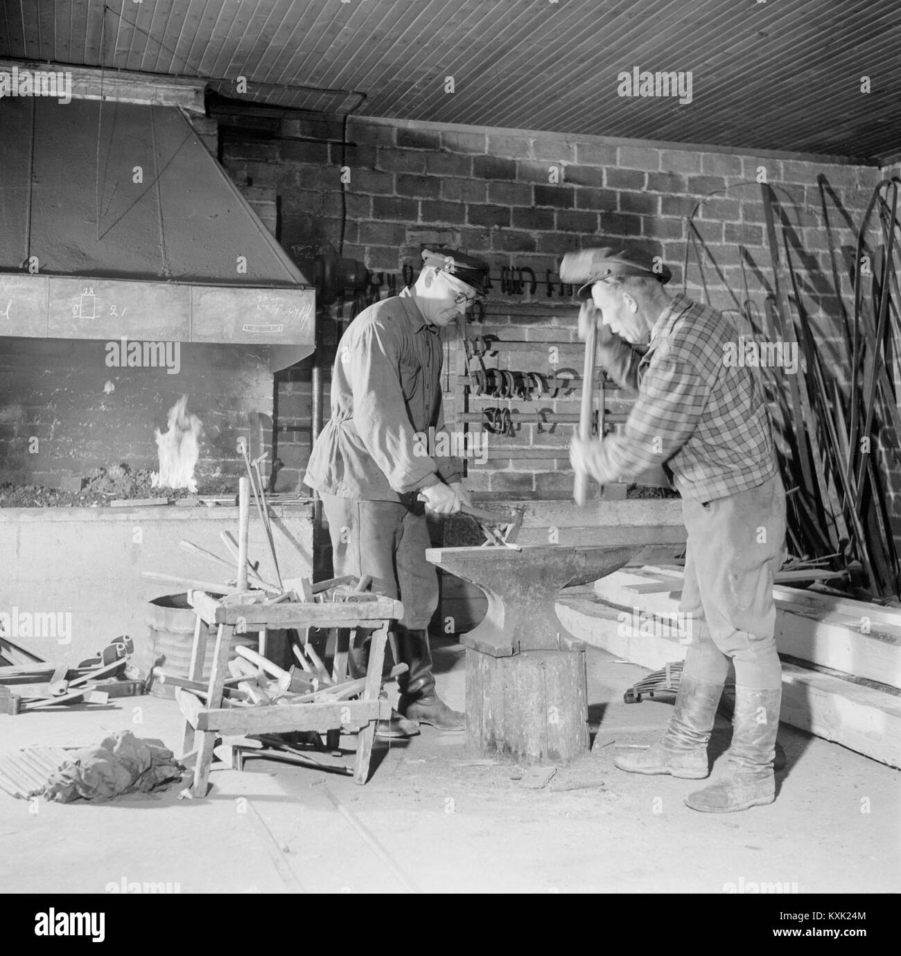 Deux hommes qui travaillent avec le métal forgeron forge, Finlande, 1950 Banque D'Images