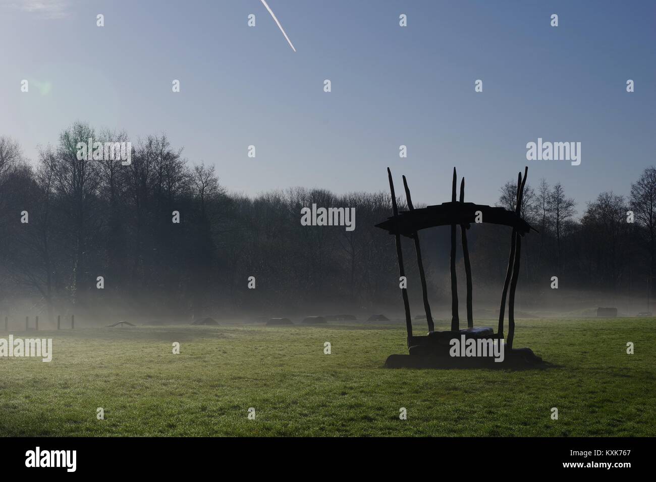 Abri banc rustique en silhouette sur un hivers brumeux matin sur un champ d'herbe par Ludwell Valley Park. Exeter, Devon, UK. Janvier, 2018. Banque D'Images