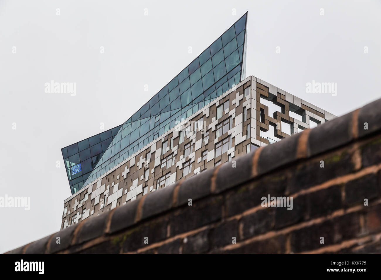 Un vieux mur sur le côté du canal à Birmingham contraste avec la couronne sur le dessus de la nouvelle construction de cube dans le centre-ville. Cet édifice complet Banque D'Images