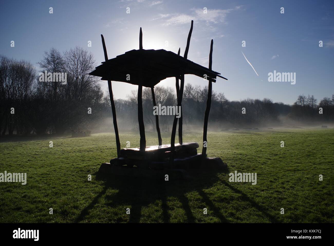 Abri banc rustique en silhouette sur un hivers brumeux matin sur un champ d'herbe par Ludwell Valley Park. Exeter, Devon, UK. Janvier, 2018. Banque D'Images