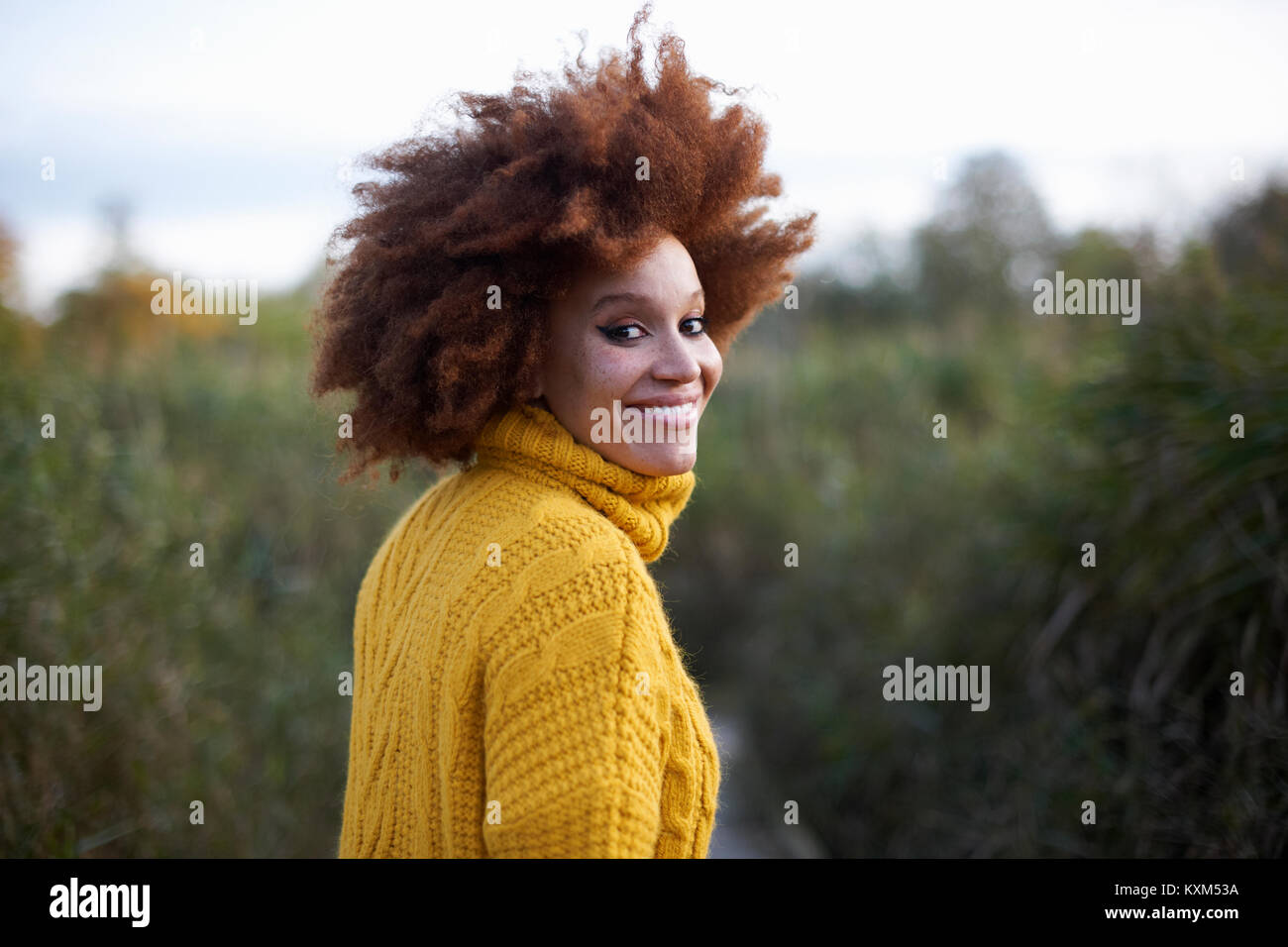 Portrait de femme avec de l'afro souriant de l'appareil photo Banque D'Images