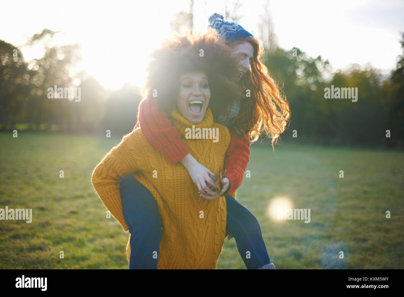 Deux jeunes femmes, en milieu rural, young woman giving ami piggyback ride Banque D'Images