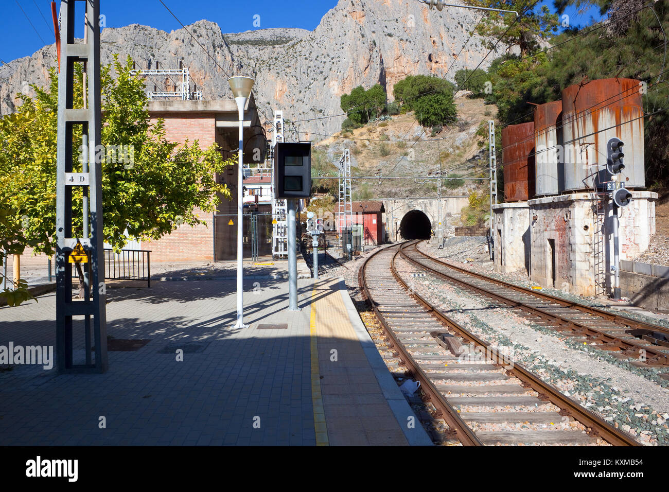 El Chorro gare en andalousie espagne avec une ligne de chemin de fer dans un tunnel en courbe et la roche sous un ciel bleu Banque D'Images