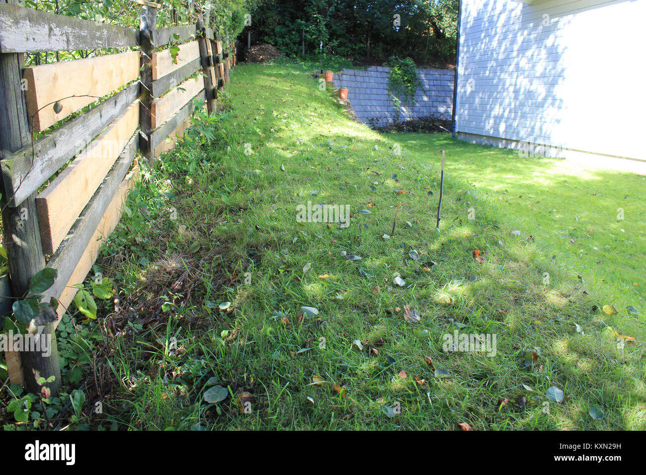 Photographie montrant une pelouse avec un bord tampon de finition avant une pente, illustrant les techniques de conception de paysage et de jardin. Banque D'Images