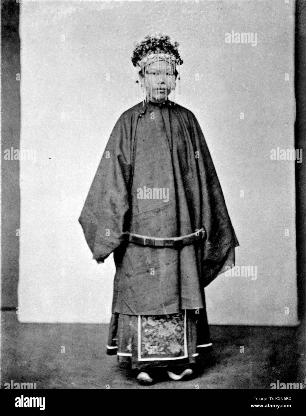 Portrait d'une mariée vêtue d'une tenue formelle pour une cérémonie de mariage, présentant généralement une robe, un voile et des accessoires de mariée. L'image capture l'élégance et la tradition associées aux mariages. Banque D'Images