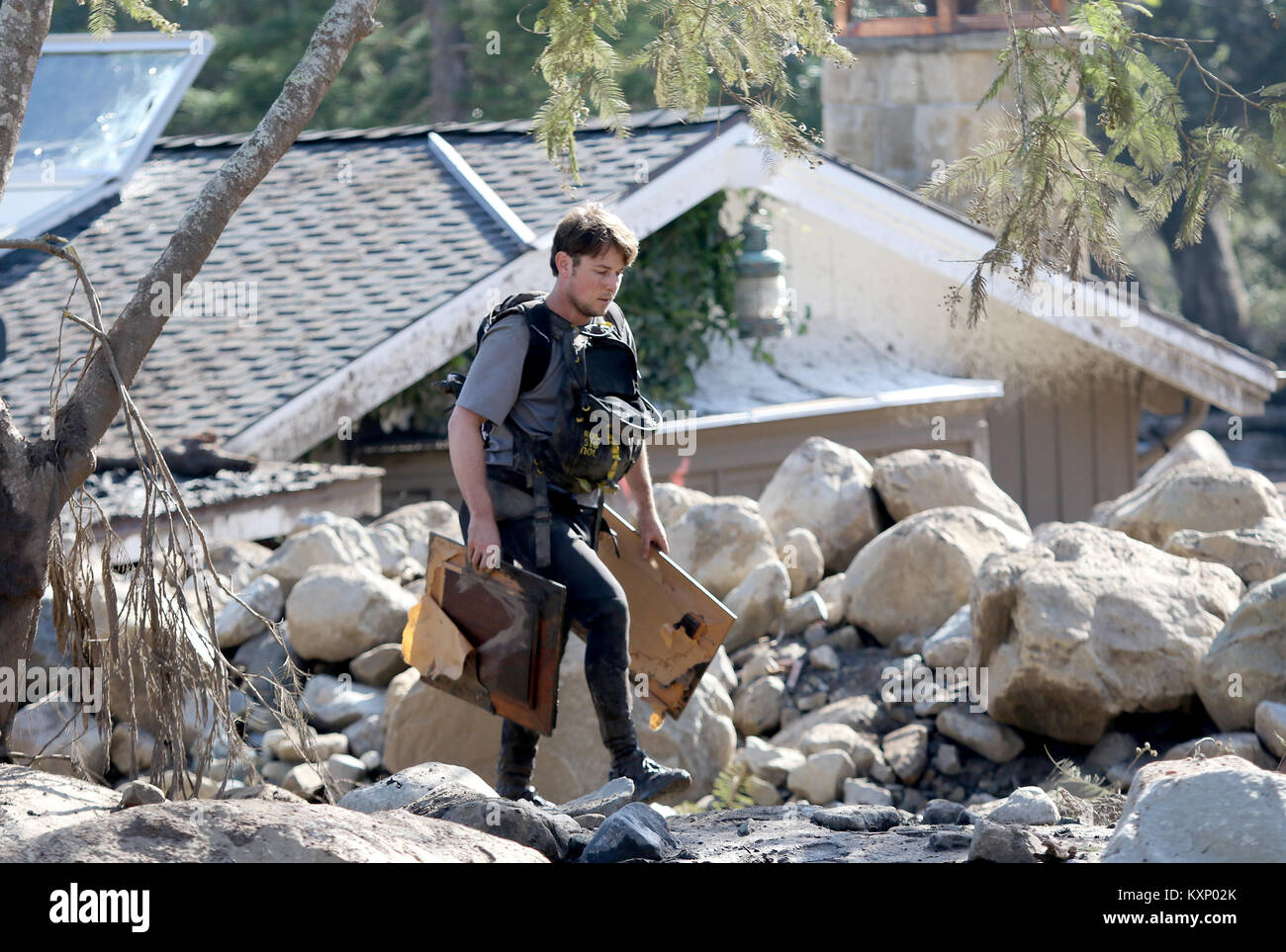 Montecito, Californie, USA. Jan 11, 2018. Un jeune homme s'éloigne de sa maison qui a été détruit dans l'énorme coulée de Montecito, CA, l'exécution d'images encadrées le mercredi 11 janvier 2018. Crédit : Daniel Dreifuss/Alamy Live News Banque D'Images