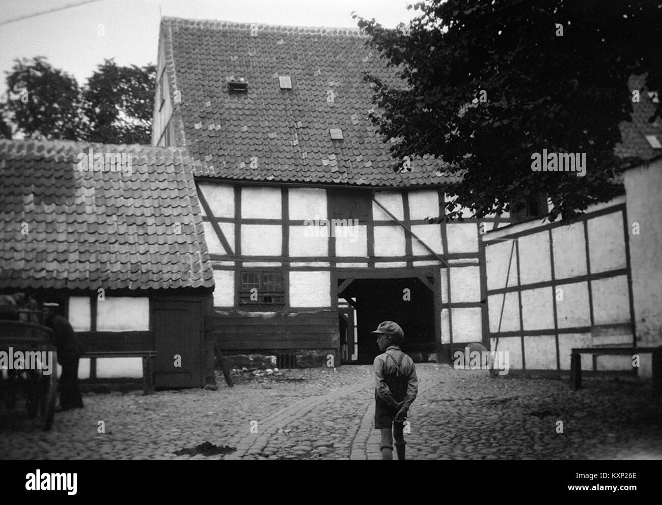 Photographie d'un garçon dans une cour à Ystad, Skåne, Suède, illustrant la vie quotidienne, l'architecture, et la disposition spatiale de la zone résidentielle. Banque D'Images