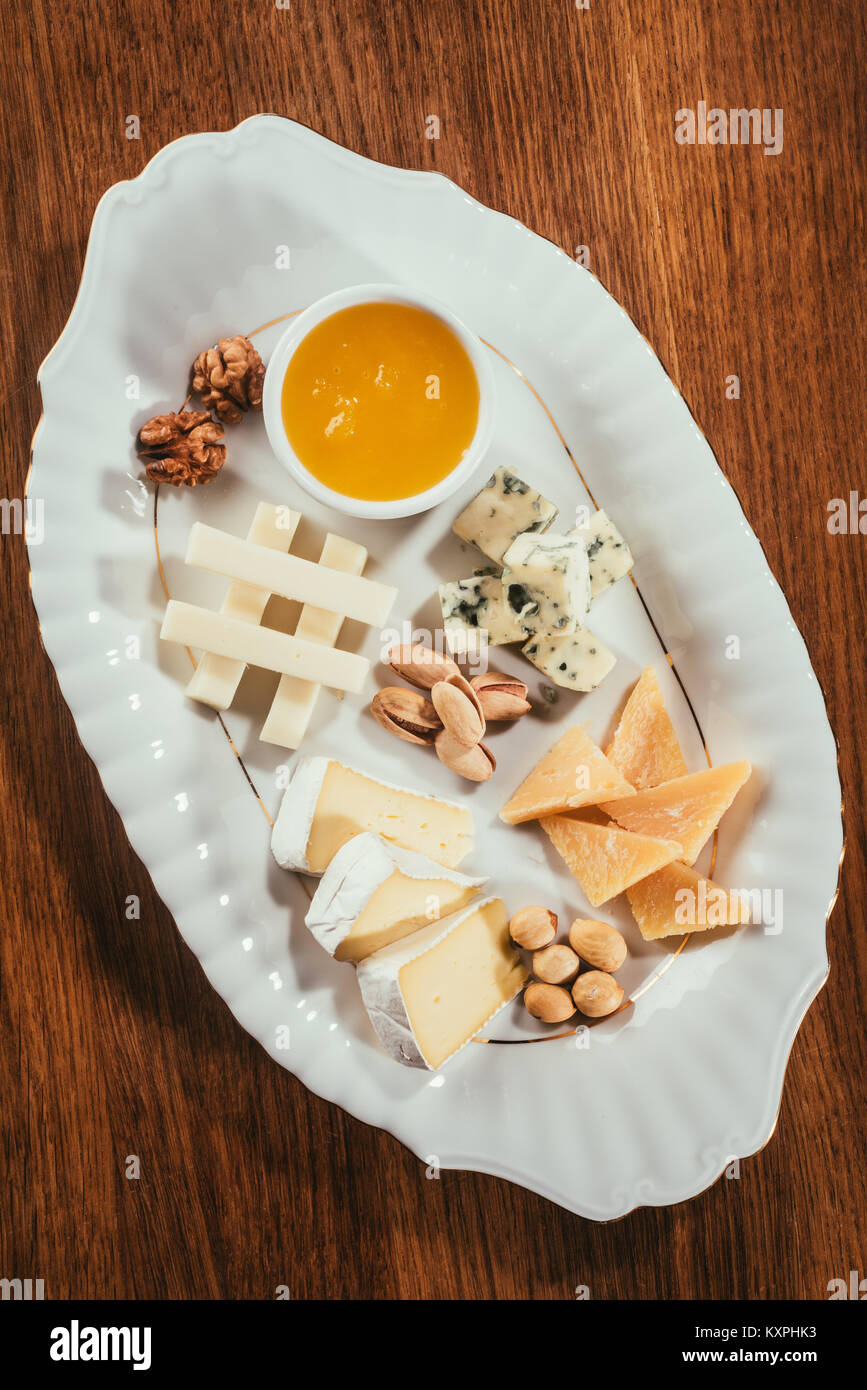 Vue du dessus de l'assiette de fromage aux noix et sauce sur table en bois Banque D'Images