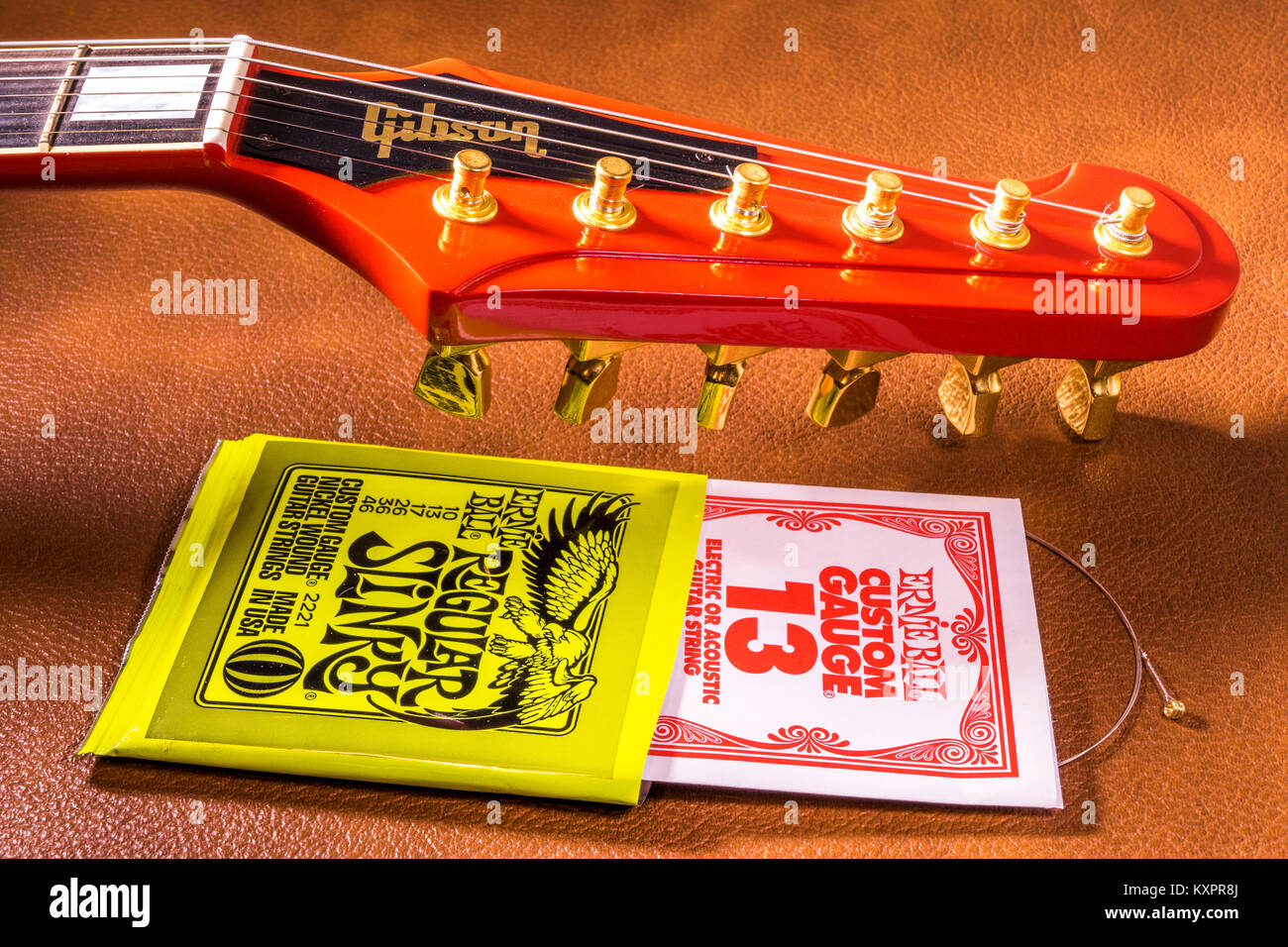 Gibson Firebird guitare électrique guitare, à côté d'un ensemble de cordes Ernie Ball, avec un string qui dépasse de son paquet. Les deux produits made in USA. Banque D'Images