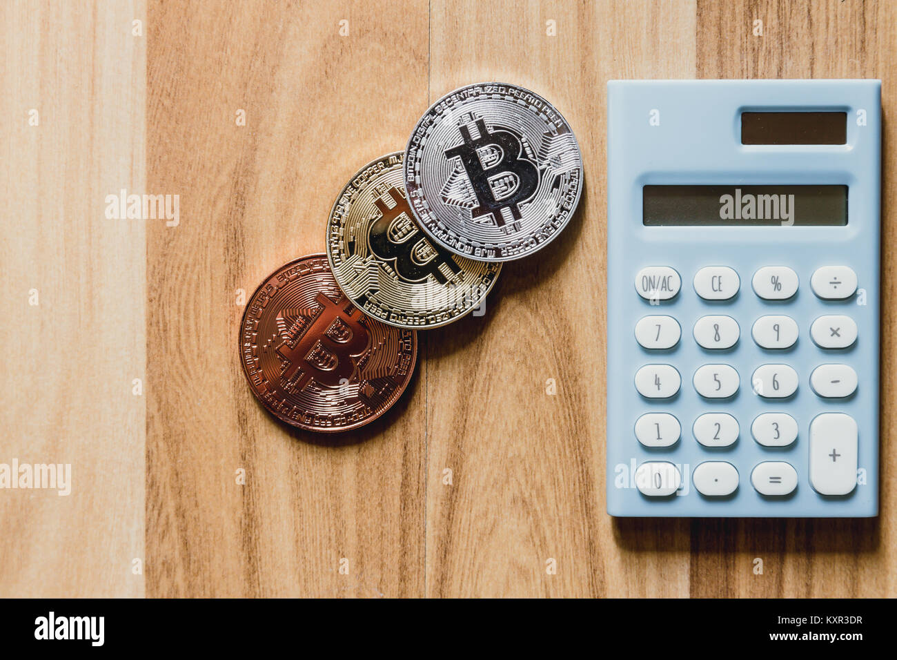 Numérique bitcoin cryptocurrency avec calculatrice sur plancher bois Banque D'Images