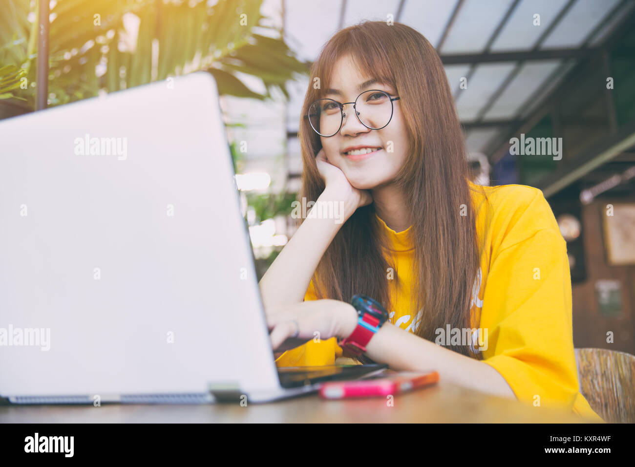 Teen asiatique en verre blanc waring hipster slim peau avec ordinateur portable dans ton vintage cafe Banque D'Images