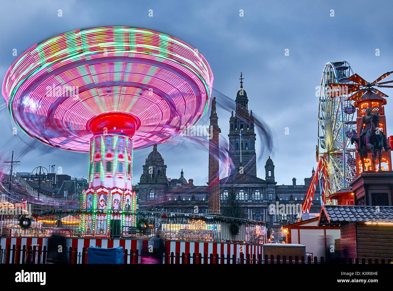 Foire de Noël avec carrousels tournant sur George Square dans la ville de Glasgow, en Écosse. Banque D'Images