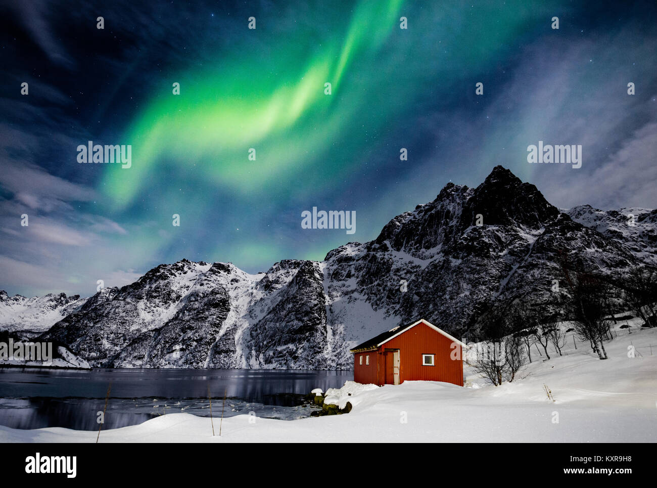 Les Lofoten, Svolvær, Aurora Borealis, sur un lac gelé et rouge, en Norvège. rorbu Banque D'Images